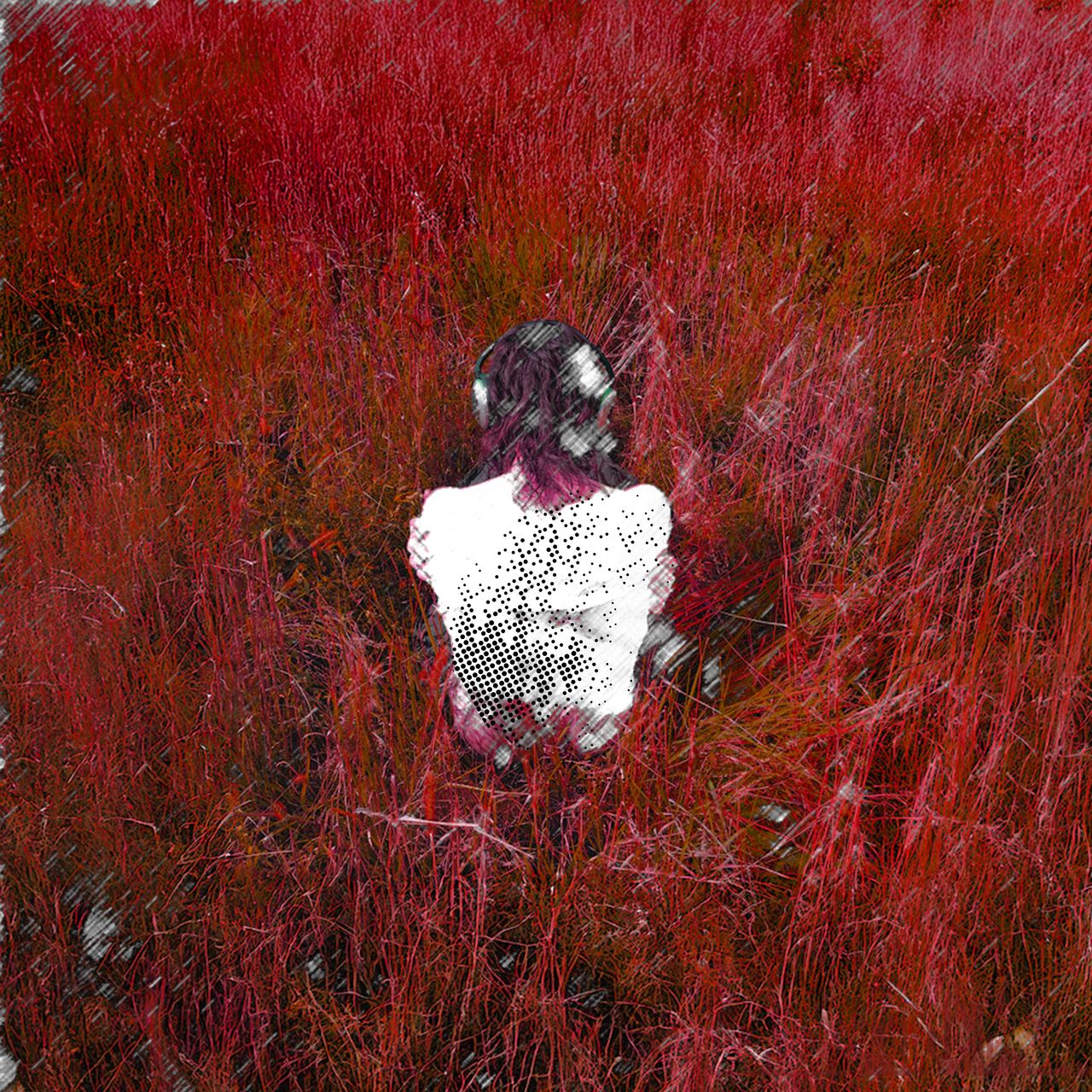 aubrey black sitting in a field of grass with their bare back to the camera. all the grass in the field has been turned red.