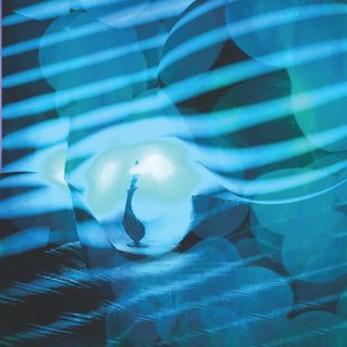 blue and dark blue stripes irregularly cast across a formless room where there is a distorted lamp trapped in a sphere in the center of the room. another shadow sphere lurks ominously above the trap sphere.